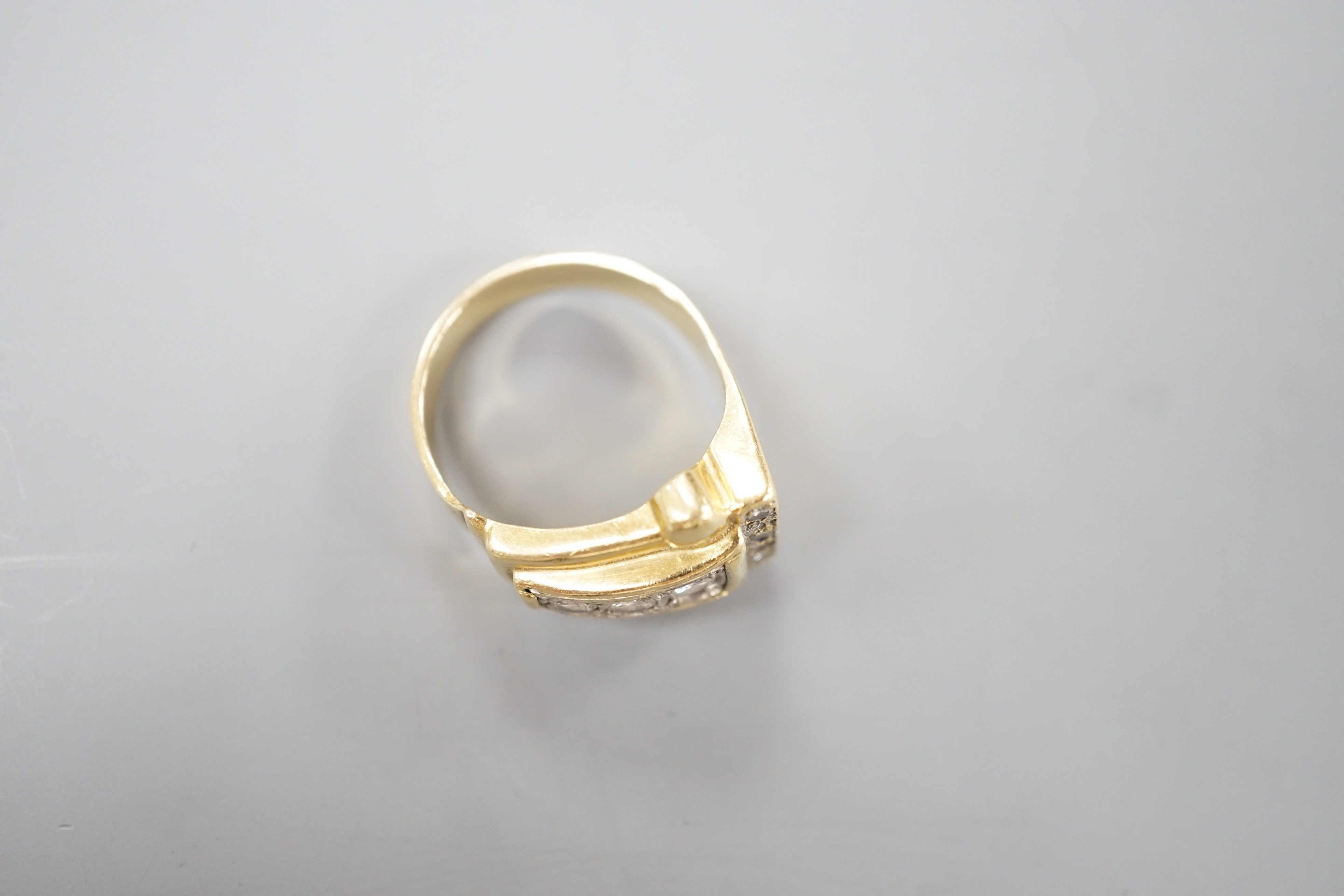 A 1950's yellow metal and graduated eight stone diamond set dress ring, size P/Q, gross 10 grams.